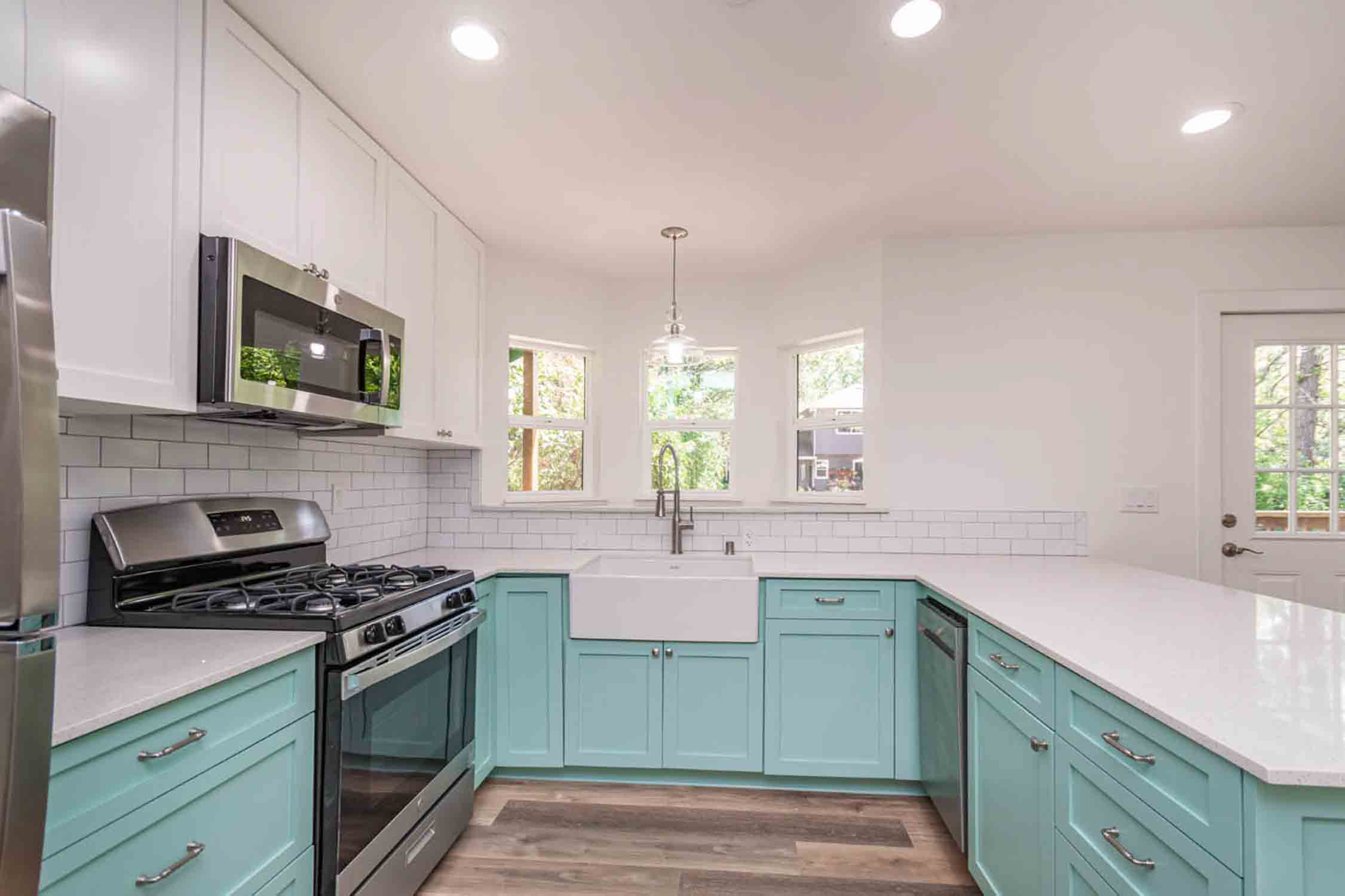  Tiny house companies and their project of a mint green kitchen in a home.